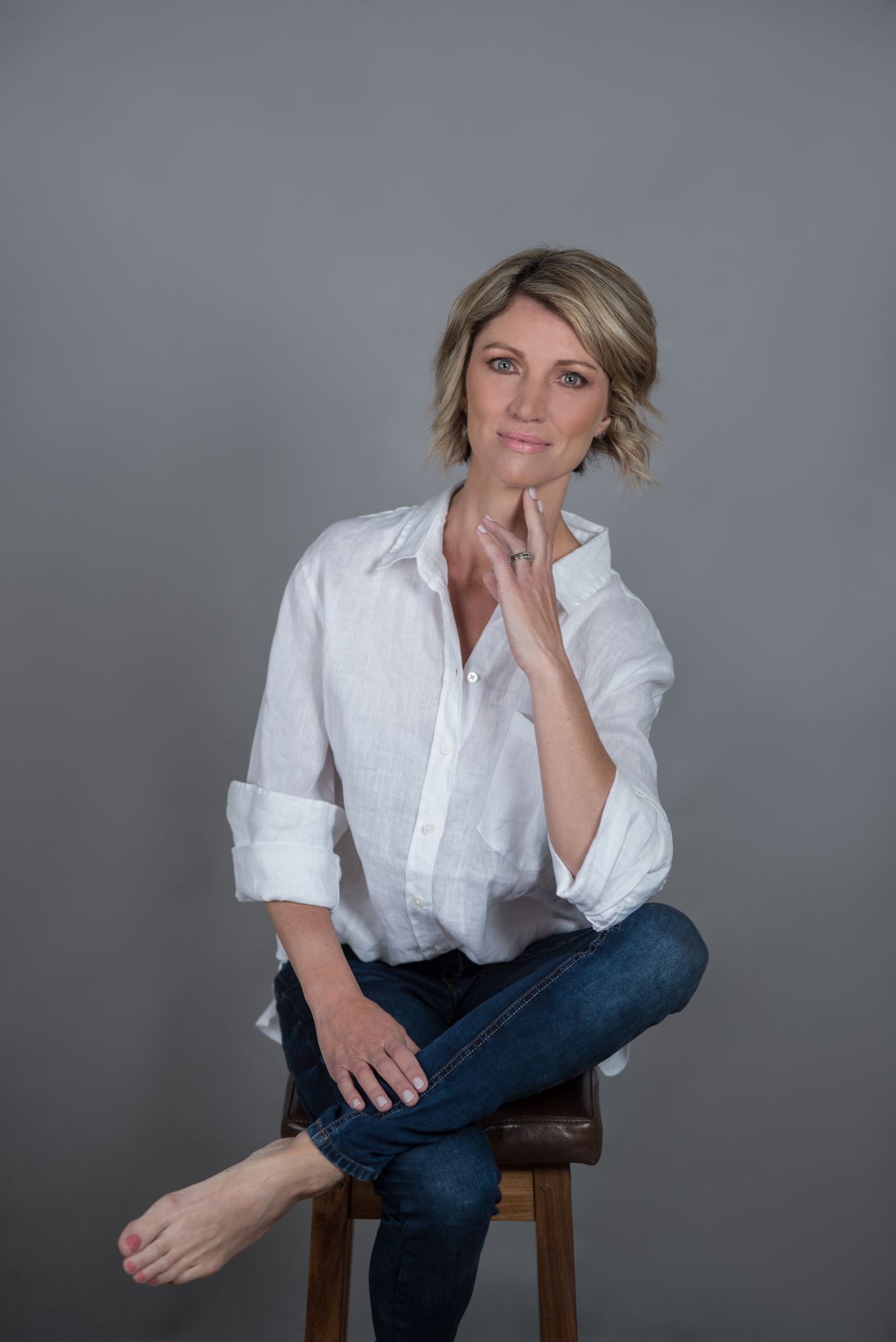 Blonde woman in a white linen shirt on a stool — studio portrait photography in Cape Town